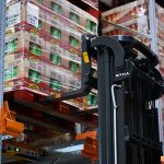 Wózek wysokiego składowania STILL FM-X odkładający paletę na regał w Kellogg's